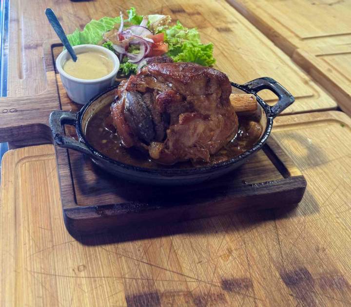 Jambonneau servi avec une sauce et une salade Valergues