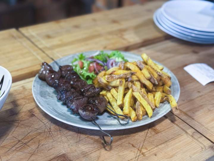 Brochettes de viande grillée, servies avec des frites croustillantes et une salade fraîche Valergues